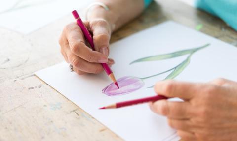 person drawing with colored pencils