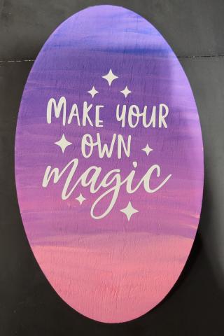 oval painted board that says "make your own magic"