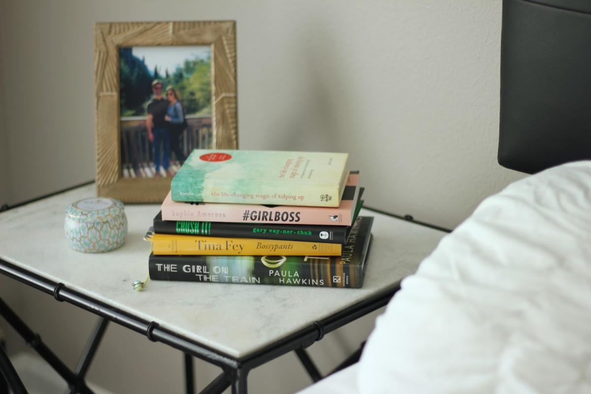 books in a stack on a bedside table