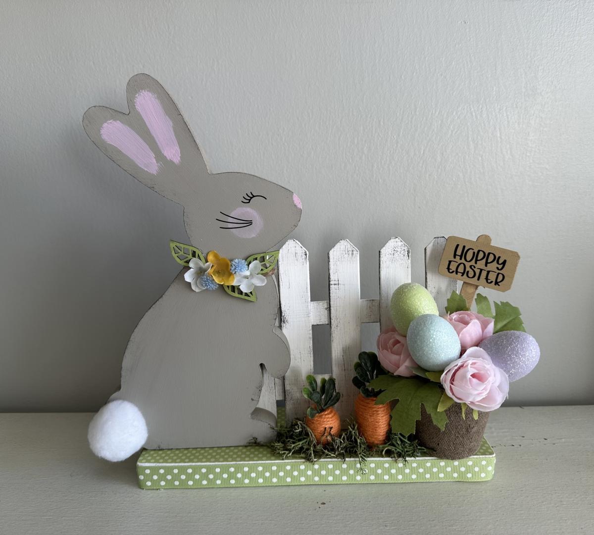 bunny near a fence with flowers