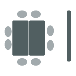 Two tables pushed together surrounded by eight chairs and a screen.